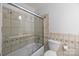 A tiled bathroom featuring a glass enclosed tub and shower as well as a toilet at 11329 Torino Rd, Matthews, NC 28105