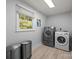 Efficient laundry room with modern washer and dryer set, natural light, and ample space at 11329 Torino Rd, Matthews, NC 28105