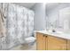Well-lit bathroom with a wooden vanity, decorative mirror, and a shower with a patterned curtain at 129 Nims Spring Dr, Fort Mill, SC 29715