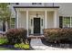Welcoming front porch featuring classic columns, manicured bushes and a black door at 129 Nims Spring Dr, Fort Mill, SC 29715