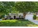 Attractive home exterior with a well-kept lawn, mature tree, and inviting front porch at 129 Nims Spring Dr, Fort Mill, SC 29715