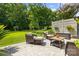 Outdoor seating area with cushioned chairs, patterned stone, privacy fencing, and a view of the lush green yard at 129 Nims Spring Dr, Fort Mill, SC 29715