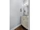 Charming powder room features a vanity with marble countertop and warm wood flooring at 129 Nims Spring Dr, Fort Mill, SC 29715