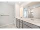 Bright bathroom featuring a double vanity with gray cabinets and a glass-enclosed shower at 12912 Canterbury Castle Dr, Charlotte, NC 28273