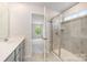 Bathroom featuring a glass enclosed shower, tiled walls, and a window bringing in natural light at 12912 Canterbury Castle Dr, Charlotte, NC 28273