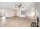 Open living room flows to the kitchen with light wood floors and ceiling fan at 12912 Canterbury Castle Dr, Charlotte, NC 28273