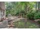 Landscaped backyard features mature trees, plantings, and garden accents, creating a serene and private outdoor oasis at 140 Rustic Way Ln, Mooresville, NC 28117