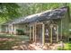 View of backyard with chicken coop, lush green lawn, and privacy provided by mature trees, perfect for outdoor living at 140 Rustic Way Ln, Mooresville, NC 28117