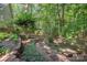 Lush backyard featuring trees, plantings, and garden accents, creating a serene and private outdoor retreat at 140 Rustic Way Ln, Mooresville, NC 28117