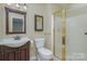 Bathroom with a vanity sink, toilet, and shower featuring brass trim, giving a functional space a traditional feel at 140 Rustic Way Ln, Mooresville, NC 28117