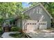 Charming home featuring an attached two-car garage, beautiful trees, and well-maintained landscaping at 140 Rustic Way Ln, Mooresville, NC 28117
