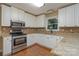 Well-lit kitchen with stainless steel appliances, granite countertops, and white cabinets at 140 Rustic Way Ln, Mooresville, NC 28117