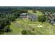 Aerial view of the golf course, a clubhouse, a pool, tennis courts, and other community amenities nestled within lush greenery at 14103 Hiawatha Ct, Huntersville, NC 28078