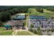 Aerial view of community amenities including a clubhouse, pool, sand volleyball, tennis courts, parking, and golf course at 14103 Hiawatha Ct, Huntersville, NC 28078