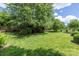 A lush backyard features an expansive lawn, mature trees, and refined landscaping, creating a picturesque outdoor setting at 14103 Hiawatha Ct, Huntersville, NC 28078