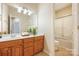 A well-lit bathroom featuring a wood vanity with a clean white countertop and a combined shower and tub at 14103 Hiawatha Ct, Huntersville, NC 28078