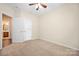 Neutral bedroom with double door closet, neutral walls, tan carpet, ceiling fan, with bathroom access at 14103 Hiawatha Ct, Huntersville, NC 28078