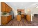 Open kitchen with wood cabinets, stainless steel appliances, granite countertops, and wood-look flooring at 14103 Hiawatha Ct, Huntersville, NC 28078