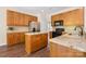 Well-lit kitchen with granite countertops, stainless steel appliances, wood cabinets, and wood-look flooring at 14103 Hiawatha Ct, Huntersville, NC 28078