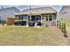 Backyard area with a hot tub, grill, covered patio, and green lawn surrounded by a fence at 15614 Aviary Orchard Way, Charlotte, NC 28278