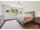 Bright bedroom with a ceiling fan, large window, and soft neutral decor and carpet at 15614 Aviary Orchard Way, Charlotte, NC 28278