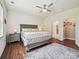 Spacious bedroom with a ceiling fan, natural light, wood floors, and access to a bathroom at 15614 Aviary Orchard Way, Charlotte, NC 28278