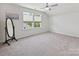 Open bedroom with carpeted floors, a standing mirror, and multiple windows for natural light at 15614 Aviary Orchard Way, Charlotte, NC 28278
