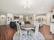Open dining area with wood floors, a round table, and seamlessly connecting to a living room and modern kitchen at 15614 Aviary Orchard Way, Charlotte, NC 28278