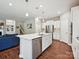Bright, modern kitchen with stainless steel appliances, white cabinets and island with a sink at 15614 Aviary Orchard Way, Charlotte, NC 28278