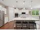 Stylish kitchen island with white cabinetry, stainless appliances and pendant lighting at 15614 Aviary Orchard Way, Charlotte, NC 28278