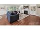 Cozy living room with a fireplace, built-in shelves, and large windows with natural light at 15614 Aviary Orchard Way, Charlotte, NC 28278
