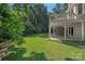 A well-maintained back yard with a covered porch and a view of the surrounding trees at 15724 Eagleview Dr, Charlotte, NC 28278