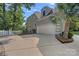 The exterior features an attached three-car garage and landscaped yard with mature trees and shrubs at 15724 Eagleview Dr, Charlotte, NC 28278