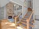 Staircase boasts tile risers, wood treads, and iron railings, leading to a living room with a stone fireplace at 15724 Eagleview Dr, Charlotte, NC 28278