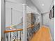 Upstairs hallway with hardwood floors, iron railings, and view of the stone fireplace at 15724 Eagleview Dr, Charlotte, NC 28278