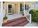 Close-up of a welcoming front porch with brick steps, potted plants, and a 'welcome' sign at 2040 Brantley Creek Dr, Kannapolis, NC 28083