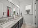 A serene bathroom boasts a large mirror, double sinks, and bright window with granite countertops at 217 Turtleback Rdg, Weddington, NC 28104