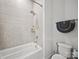 Cozy bathroom featuring a shower and tub combination and light gray tiling at 217 Turtleback Rdg, Weddington, NC 28104