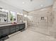 A contemporary bathroom features an artistic glass shower, dual vanities, and a bright window at 217 Turtleback Rdg, Weddington, NC 28104