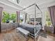 A modern bedroom boasts a canopy bed, stylish furniture and decor with lots of natural light at 217 Turtleback Rdg, Weddington, NC 28104