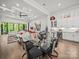 A bright dining area features a glass table, modern chairs, and a bar with wine cooler at 217 Turtleback Rdg, Weddington, NC 28104