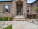 Stone entrance with a black front door, detailed iron railings and manicured landscaping at 217 Turtleback Rdg, Weddington, NC 28104