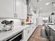 Modern kitchen with sleek white cabinets, stainless steel appliances, and hardwood floors at 217 Turtleback Rdg, Weddington, NC 28104