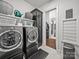 A modern laundry room with front-load washer and dryer, shelving, and stylish storage solutions at 217 Turtleback Rdg, Weddington, NC 28104