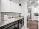 A well-organized laundry room with white and dark cabinetry and a view into an adjacent room at 217 Turtleback Rdg, Weddington, NC 28104