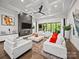 An open-concept living room features a fireplace, large windows, and bright white furniture at 217 Turtleback Rdg, Weddington, NC 28104
