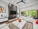 A modern living room features a fireplace with large tv, bright white furniture, and coffered ceilings at 217 Turtleback Rdg, Weddington, NC 28104