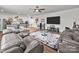 Open living room with a large rug, leather furniture, a wet bar, and a flat screen television at 217 Turtleback Rdg, Weddington, NC 28104