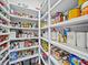 A fully stocked pantry with white shelving, showcasing an extensive selection of food and household items at 217 Turtleback Rdg, Weddington, NC 28104