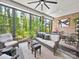 An enclosed sunroom with brick walls features large windows and wicker furniture at 217 Turtleback Rdg, Weddington, NC 28104